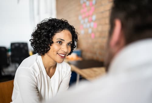 woman smiling and looking at another person