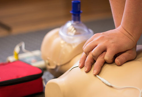 person doing CPR on CPR manikin